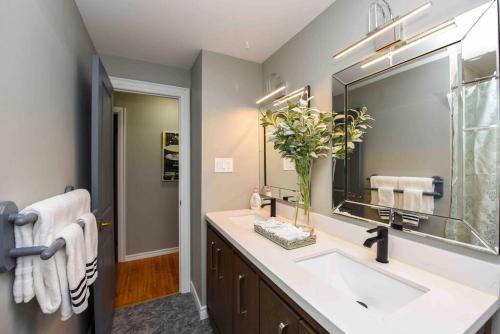 a bathroom with a sink and a large mirror at Discover Your Home Away From Home Near YYZ Airport in Mississauga