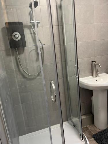 una ducha con una puerta de cristal junto a un lavabo en Very Spacious Two Bedroom Apartment en Grays Thurrock
