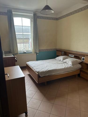 um quarto com uma cama e uma janela em ferme d'herlaimont 1 em Chapelle-lez-Herlaimont