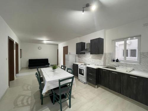 une cuisine avec une table et une salle à manger dans l'établissement Coral Cove Comfort Room 1, à San Pawl il-Baħar