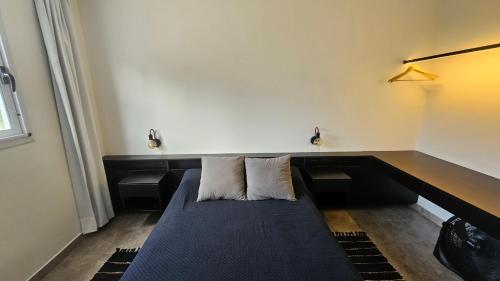 a room with a couch with two pillows on it at Casa J moderna con amplio jardín en barrio cerrado in San Salvador de Jujuy