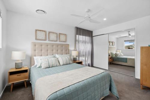 um quarto com uma cama grande e uma colcha azul em Aloha Allura em Coolum Beach