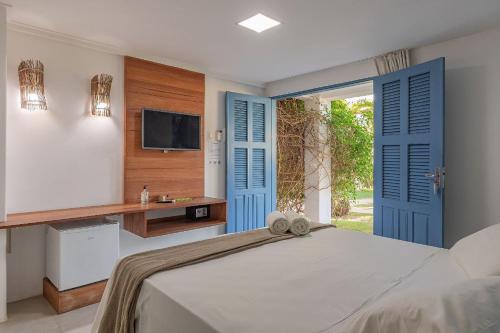 een slaapkamer met blauwe deuren en een bed en een televisie bij Pousada Katavento #Q5 - Na Praia por Carpediem in Cumbuco