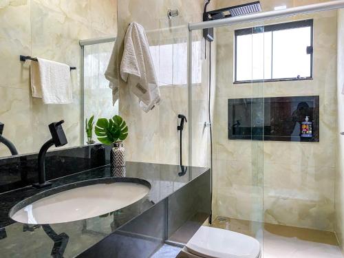 ein Bad mit einem Waschbecken und einer Dusche in der Unterkunft Casa butique veraneios 2 in Caldas Novas