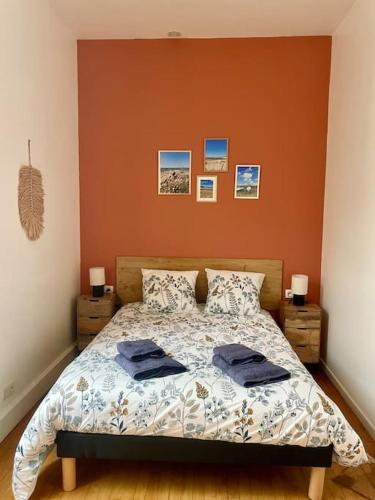 a bedroom with a bed with two blue towels on it at Madini-Breizh :T3 cœur de ville in Lannion