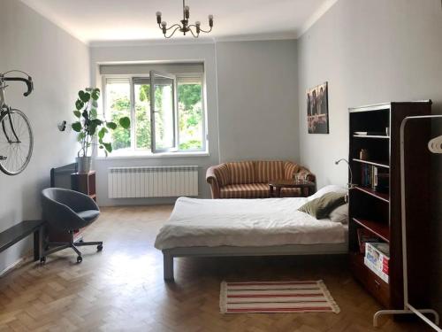 ein Schlafzimmer mit einem Bett, einem Stuhl und einem Schreibtisch in der Unterkunft Mieszkanie Centrum 60 m na wylacznosc in Lublin