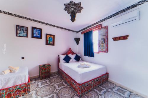 a bedroom with two beds and a window at Hotel Chefchaouen in Chefchaouene