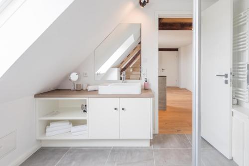a white bathroom with a sink and a staircase at Arlau Schleuse - Schleuse twee in Hattstedtermarsch