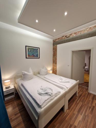 ein Schlafzimmer mit einem großen Bett mit weißer Bettwäsche in der Unterkunft Altstadt-Apartment Rothenberg in Wernigerode