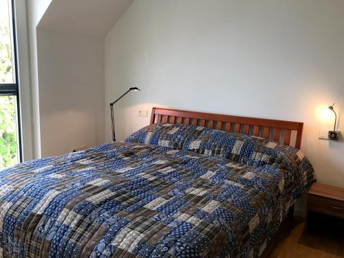 een slaapkamer met een bed met een quilt bij Ferienwohnung Urlaubsglück- lichtdurchflutete Wohnung mit Balkon und Seesicht in Lindau