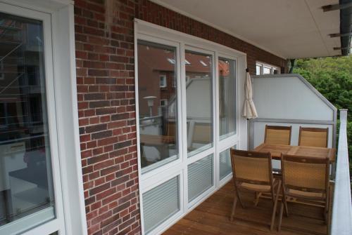 a screened in porch with a table and chairs at Strandhaus Rose in Juist