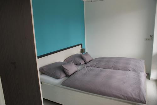 a bed with two pillows and a blue at Strandhaus Rose in Juist