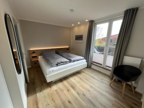 sypialnia z łóżkiem i dużym oknem w obiekcie Dünen Lodge 3 w mieście Juist