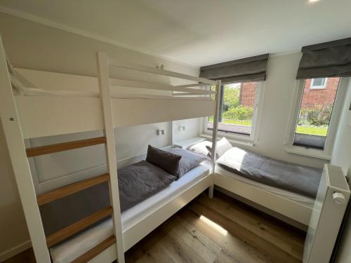 a bedroom with two bunk beds and a window at Dünen Lodge 2 in Juist