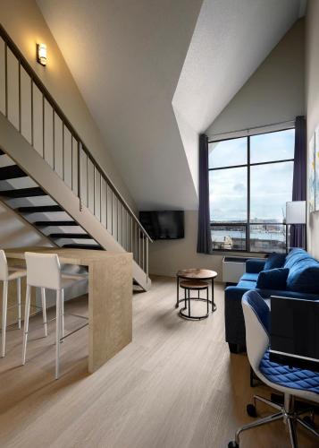 a living room with a couch and a staircase at Huntingdon Hotel and Suites in Victoria