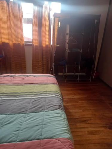 1 dormitorio con 1 cama y una ventana con cortinas en Isaac house en Puerto Natales