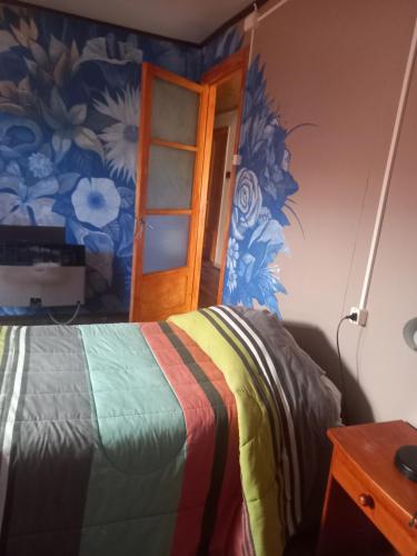 1 dormitorio con 1 cama con colcha colorida en Isaac house en Puerto Natales