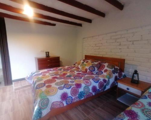 a bedroom with a bed and a brick wall at ALOJAMIENTO EL REGALO in Salento