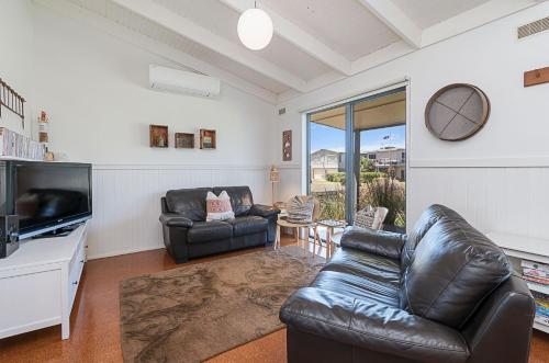 a living room with two leather chairs and a television at Ocean Spray Retreat in Port Fairy