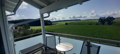a balcony with a view of a green field at Apartment Haus Maria Waldblick in Burtenbach