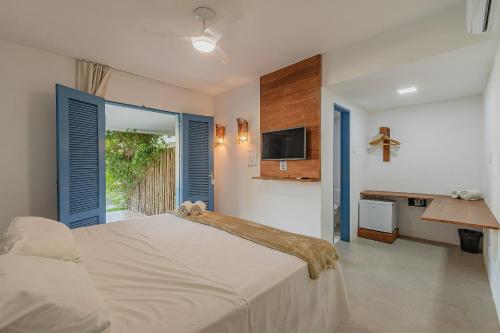 a bedroom with a bed and a tv and a window at Pousada Katavento #Q2 - Suíte Dupla por Carpediem in Cumbuco