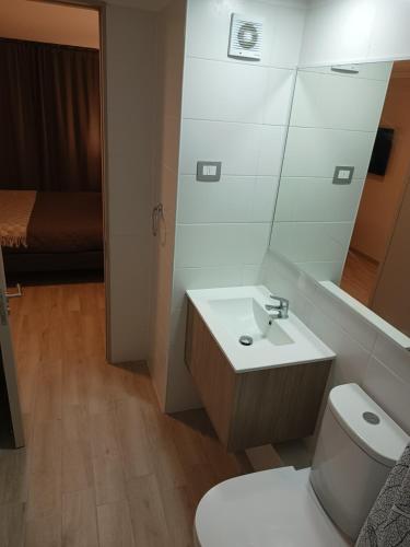 uma casa de banho com um lavatório, um WC e um espelho. em Enjoy Serena Sea View em La Serena