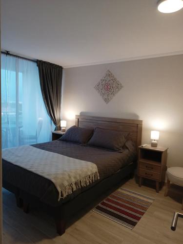 um quarto com uma cama, 2 candeeiros e uma janela em Enjoy Serena Sea View em La Serena