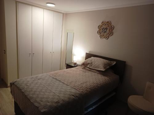 a bedroom with a bed and a cabinet and a lamp at Enjoy Serena Sea View in La Serena