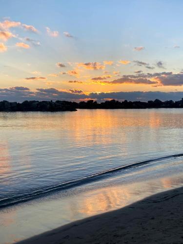 a sunset over a body of water with a beach at Olivetta House Holiday in Moneglia