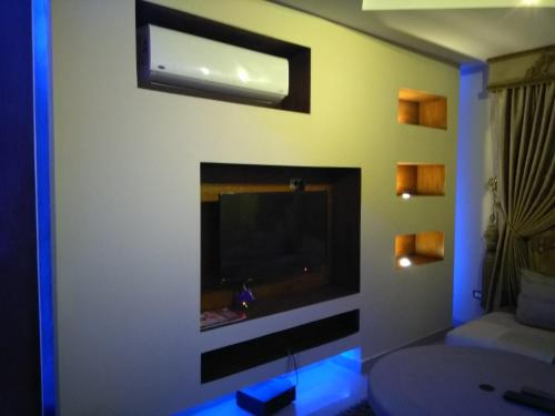 een woonkamer met een flatscreen-tv aan de muur bij 5th Settlement Shaya in Caïro