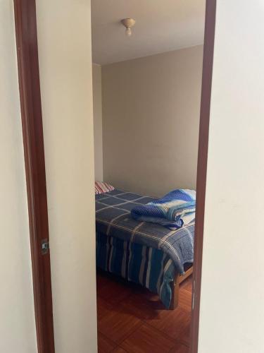 ein kleines Schlafzimmer mit einem Bett im Spiegel in der Unterkunft Habitación amoblada dentro de departamento amoblado tipo roommate in Lima
