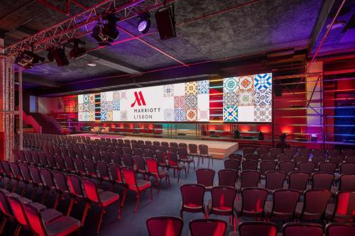 an empty auditorium with red chairs and a screen at Lisbon Marriott Hotel in Lisbon