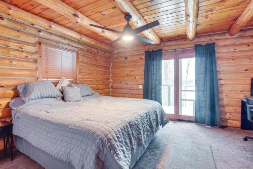 a bedroom with a bed in a log cabin at Rhinelander Waterfront Cabin with Deck and Fire Pit! in Rhinelander