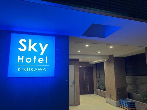 a blue hotel sign on the side of a building at SkyHotel Kikukawa 駅徒歩2分 in Tokyo