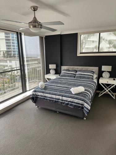 a bedroom with a bed and a ceiling fan at Queensleigh Holiday Apartments in Gold Coast