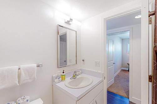 een witte badkamer met een wastafel en een spiegel bij Alpine 4 in Crested Butte