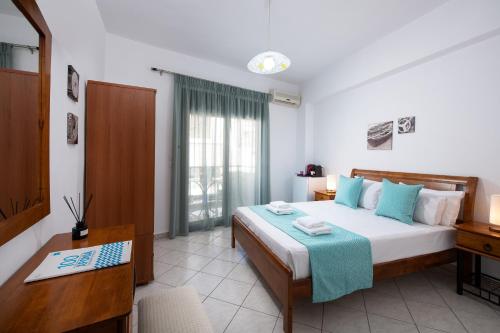 a bedroom with a bed and a desk with a computer at Kentrikon Rooms in Limenaria