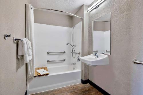 a white bathroom with a sink and a shower at Motel 6-Anaheim, CA - Fullerton East in Anaheim