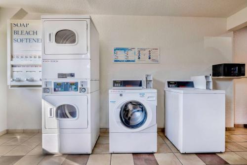 a laundry room with two machines and a washer and dryer at Motel 6-Anaheim, CA - Fullerton East in Anaheim