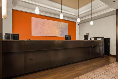 a lobby with a reception desk and an orange wall at Best Western The Plaza Hotel Honolulu Airport - Free Breakfast in Honolulu