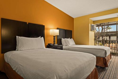 a hotel room with two beds and a window at Best Western The Plaza Hotel Honolulu Airport - Free Breakfast in Honolulu