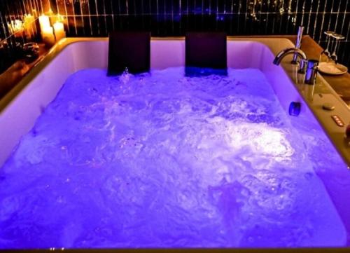 una piscina de agua púrpura con una persona en ella en MILUAR Luxury B&B - Vanvitelli, en Nápoles