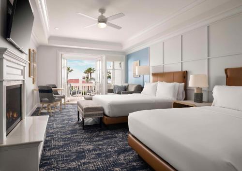 a hotel room with two beds and a fireplace at Beach Village at The Del, Curio Collection by Hilton in San Diego