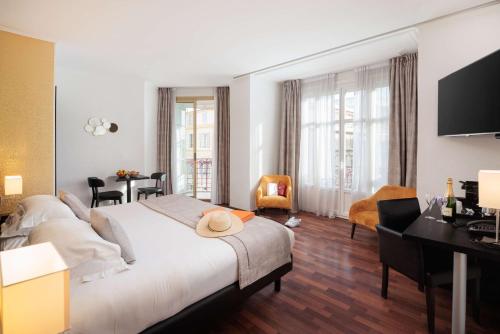 a hotel room with a large bed and a desk at Best Western Plus Hôtel Massena Nice in Nice