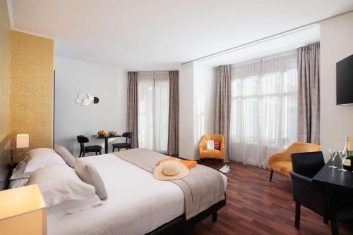 a hotel room with a large bed and a desk at Best Western Plus Hôtel Massena Nice in Nice