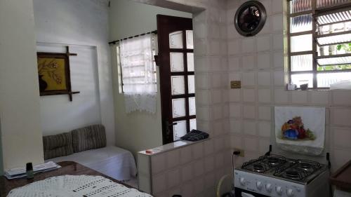 een kleine keuken met een fornuis en een raam bij Recanto do Sossego in Caraguatatuba
