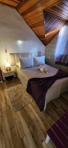 a bedroom with a large bed and a window at Pousada Araucária Suítes in Campos do Jordão