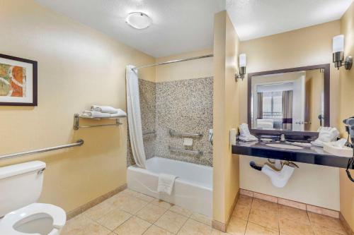 uma casa de banho com um WC, um chuveiro e um lavatório. em Comfort Suites em Blythe