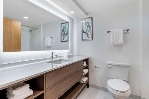 a bathroom with a sink and a toilet and a mirror at Comfort Inn Marina on the Monterey Bay in Marina