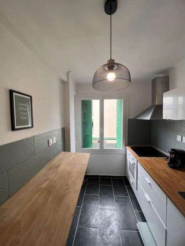 eine Küche mit einem Holztisch und einem Fenster in der Unterkunft Joli app. lumineux gare st Charles in Marseille